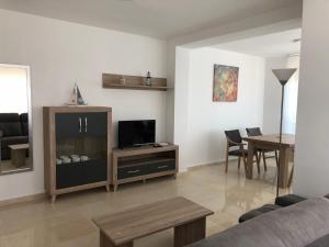 salon z kanapą, telewizorem i stołem w obiekcie Torre Levante Plus - Arca Rent w mieście Benidorm