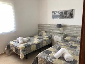 sypialnia z dwoma łóżkami i stołem z lampą w obiekcie Torre Levante Plus - Arca Rent w mieście Benidorm
