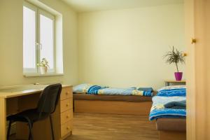 a bedroom with two beds and a desk and a desk at Danubius Szálló in Komárno