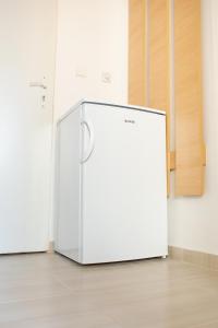 a white refrigerator sitting in a room at Danubius Szálló in Komárno
