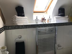 - Baño con toallas en la encimera en Peacock Cottage, Coity Bach, en Talybont