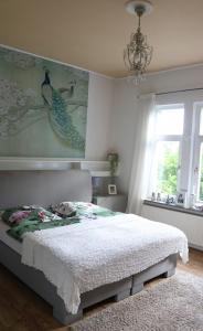 a bedroom with a bed and a chandelier and a window at Villa Elisenruh in Schmalfeld