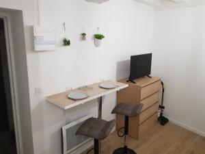 un bureau avec un bureau, un ordinateur et deux tabourets dans l'établissement La Fauconnerie Studio de charme au cœur d'Orléans, à Orléans