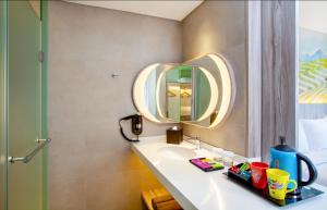 un bagno con lavandino e specchio di ibis Styles Bandung Grand Central a Bandung