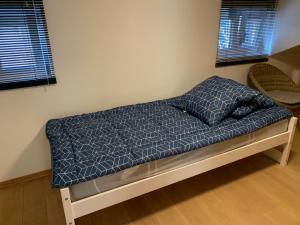 - un lit avec une couette bleue dans une chambre dans l'établissement Sapin Vert, à Leysin