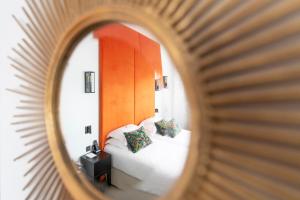 espejo reflejo de un dormitorio con 2 camas en Hôtel La Comtesse, en París