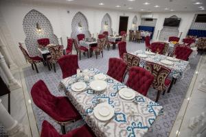 a dining room with tables and red chairs at The Shahar in Tashkent +40 photos