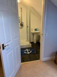 a bathroom with a toilet and a sink and a door at Riverside B&B in Kidwelly