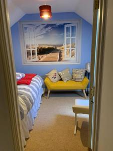 KidwellyにあるRiverside B&Bのベッドルーム1室(ベッド1台、窓、ソファ付)