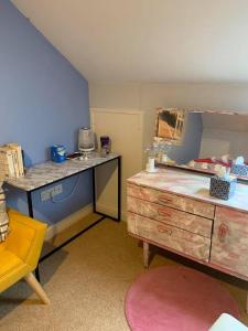 a room with a desk and a dresser with a mirror at Riverside B&B in Kidwelly