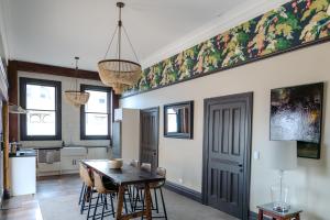 a kitchen and dining room with a table and chairs at The Old Confectionery in Oamaru