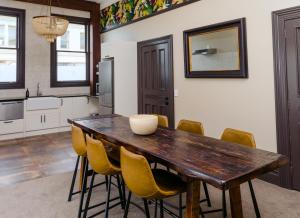 a kitchen with a wooden table and yellow chairs at The Old Confectionery in Oamaru