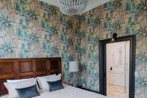a bedroom with a bed and floral wallpaper at The Old Confectionery in Oamaru