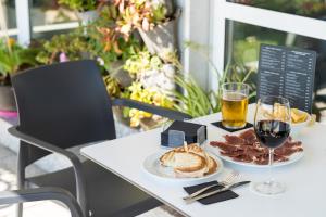 una mesa con un plato de comida y una copa de vino en Hotel Avenida, en San Sebastián