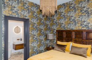 a bedroom with a bed and a blue and yellow wall at The Old Confectionery in Oamaru