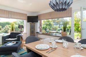 a living room with a wooden table and chairs at Haus 32 in Wenningstedt