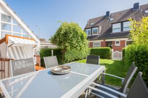 a patio with a table and chairs in a yard at Alte Liebe in Westerland (Sylt)