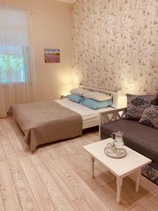 a bedroom with a bed and a couch and a table at WINE & ROSE BOUTIQUE HOTEL in Kharkiv