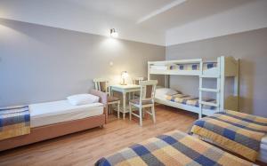 Zimmer mit 2 Betten, einem Schreibtisch und einem Etagenbett in der Unterkunft Batory Annex in Krakau