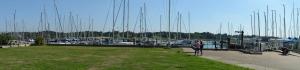 a marina with boats and people walking on a sidewalk at Riverside House in Hamble