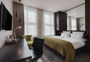 um quarto com uma cama, uma secretária e uma cadeira em Holiday Inn Dresden - Am Zwinger, an IHG Hotel em Dresden