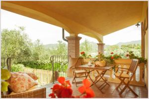une terrasse couverte avec une table et des chaises. dans l'établissement Agriturismo Costa Etrusca, à San Vincenzo