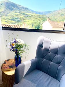 una silla azul y una mesa con un jarrón de flores en 2 bedrooms house with wifi at Viguera, en Viguera