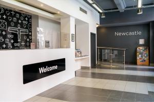 a lobby with a welcome sign on the wall at easyHotel Newcastle in Newcastle upon Tyne