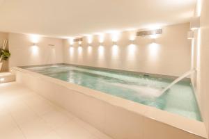 a swimming pool with a tub in a bathroom at Du Côté Des Olivades in Paradou