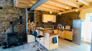 a kitchen with a stone wall and a stove at Rennscheune - Himmlisch in die Grüne Hölle in Kelberg