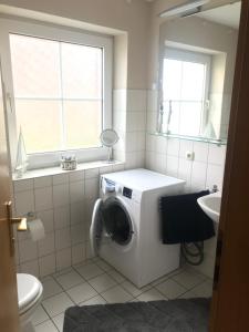 a bathroom with a washing machine and a sink at Buxbuddies Admirals Inn in Fehmarn