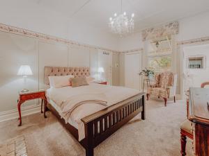 sypialnia z dużym łóżkiem i krzesłem w obiekcie Genesta House w mieście Cowes