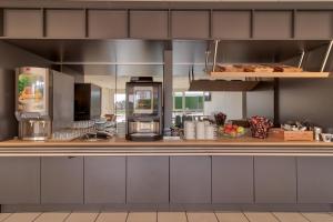 a kitchen with a counter with food on it at B&B HOTEL Pau Lescar in Lescar