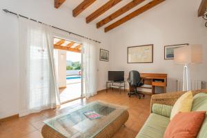 een woonkamer met een bank en een bureau bij Villa Alcaufar in S'Algar