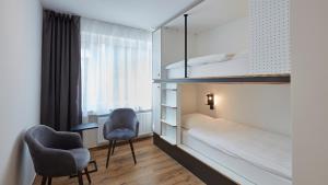 埃森The Bunk Hostel的小房间设有双层床和椅子