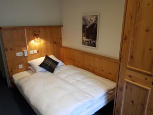 ein Schlafzimmer mit einem weißen Bett und einem Kissen darauf in der Unterkunft Spenglers Inn in Davos