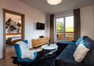 Una sala de estar con un sofá, una mesa y una cama. en Villa LiptovMara, en Ižipovce
