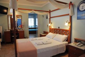 um quarto com uma cama e um relógio na parede em ALK Hotel em Kamari
