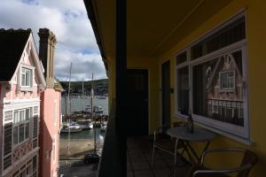 einen Balkon mit einem Tisch und Blick auf den Yachthafen in der Unterkunft Riverside 6 in Dartmouth