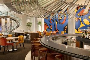 a restaurant with chairs and tables and a mural at Hotel Indigo Atlanta Downtown, an IHG Hotel in Atlanta