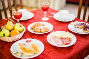a red table with plates of food and glasses of wine at Hotel Zodiaco & Spa in Vaneze