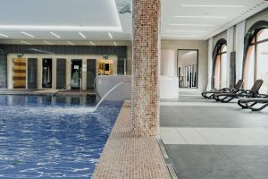 a swimming pool with a fountain in a building at Hotel Pałac Krotoszyce Basen&Spa in Krotoszyce