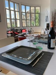 a table with a tray with glasses and a bottle of wine at Loft des Sacres - Vue unique sur la Cathédrale in Reims