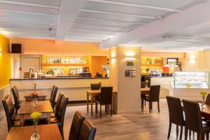 um restaurante com mesas e cadeiras e um bar em Green Hotel em Kinross