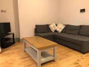 a living room with a couch and a coffee table at Belmont - Y Prom in Aberystwyth