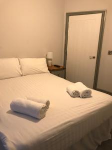 1 dormitorio con 1 cama con toallas en Belmont - Y Prom, en Aberystwyth