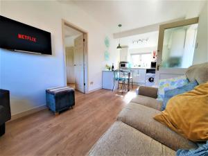 a living room with a couch and a kitchen at The Granary in Ruthin