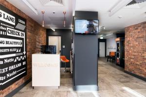 a lobby with a tv in a brick wall at easyHotel Leeds in Leeds