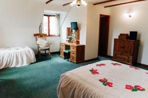 a bedroom with two beds and a dresser and a desk at The Farmhouse Lochmeyler in Llandeloy
