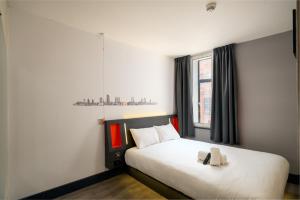 Un pat sau paturi într-o cameră la easyHotel Leeds